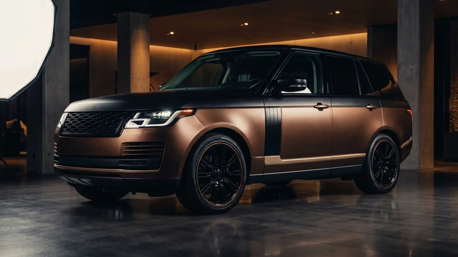 Covering SUV de luxe en bronze satin avec toit noir mat, dans un showroom underground premium