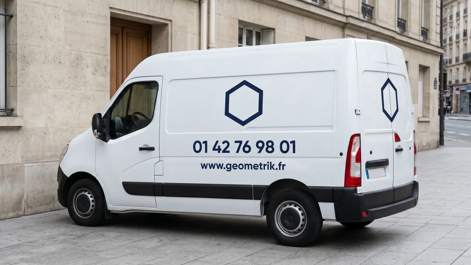 Utilitaire blanc avec lettrage vinyle discret — logo et coordonnées sur le flanc latéral