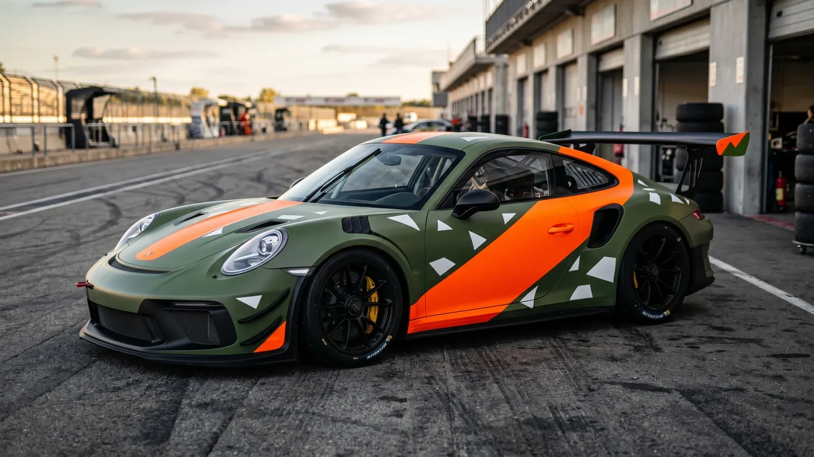 Livery racing agressive — GT en livrée vert militaire et orange fluo sur circuit